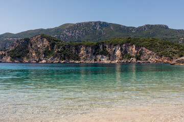 Obraz premium Panorama of beautiful Rovinia Beach with turquoise water and rocks during summer vacations, Corfu, Greece