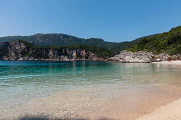 Panorama of beautiful Rovinia Beach with turquoise water and rocks during summer vacations, Corfu, Greece
