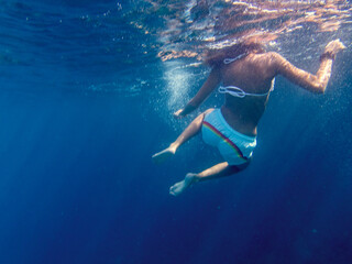 Vista subacquea di una donna che fa snorkeling in acqua blu