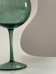 Cropped close up of smooth elegant lines of a green glass on white background