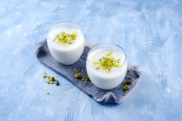 Traditional Indian lime lassi drink with dahi yogurt, lime and chopped pistachios served as...