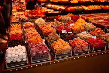 unhealthy but tasty colorful marmalade candies with a lot of sugar food background of market counter ready for selling in the Boqueria market, Barcelona (Spain), selective focus 