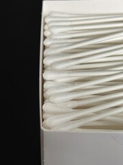 Cropped close up of a box of ear cotton swabs on black background
