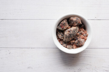 Himalayan black salt rock crystals, Kala Namak in a container on table 