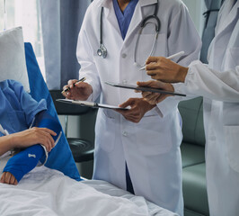 Man with broken arm in cast lying on bed in hospital. The emergency center treatment is plaster and hangs with sling for a further cure in an orthopedic clinic. Patient pain from accident injury.