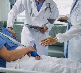 Man with broken arm in cast lying on bed in hospital. The emergency center treatment is plaster and hangs with sling for a further cure in an orthopedic clinic. Patient pain from accident injury.