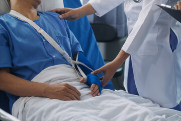 Man with broken arm in cast lying on bed in hospital. The emergency center treatment is plaster and hangs with sling for a further cure in an orthopedic clinic. Patient pain from accident injury.