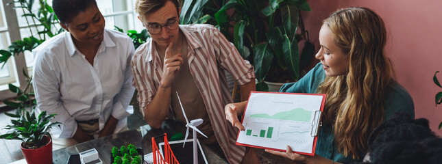 Diverse group of international students working on the urban project of modern city with renewable energy source, green areas. Concept of ecology, environment, waste recycling, technology banner