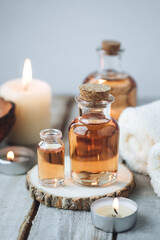 Obraz na płótnie Canvas Concept of spa treatment in salon with pure organic natural oil. Atmosphere of relax, detention. Aromatherapy, candles, towel, wooden background. Skin care, body gentle treatment