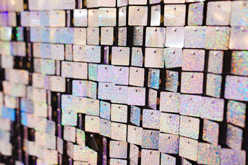 a wall of squares of shiny sequins. an element of decor for a holiday 