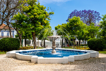 The Fonte do Jardim 1 de Dezembro fountain surrounded by lush vegetation stands in the idyllic...
