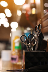 Professional hairdressing tools. Various steel scissors and combs, hairbrushes on wooden table on barbers workplace at barbershop salon. The concept of the hairdressing beauty industry. Copy space