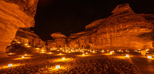Ancient tombs of Hegra city illuminated during the night panorama, Al Ula, Saudi Arabia