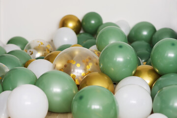 Green white transparent gold balloons yellow confetti birthday holiday celebration festive mood concept white background 
