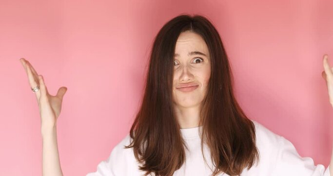 Exhausted tired young woman showing mind explosion gesture, feeling unhappy and nervous, lots unnecessary information isolated on pink background. 