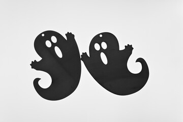 pair of halloween ornaments (ghosts) on a light background - gray scale composition