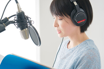 スタジオでナレーションを録音する女性ナレーター