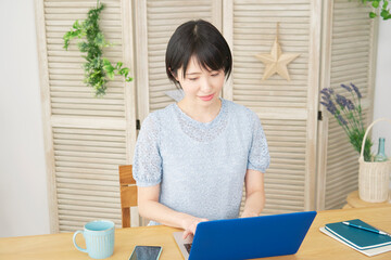 自宅でノートパソコンを使う女性