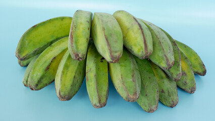 unripe green bananas on a blue background