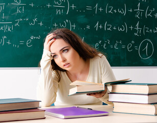 Young female math teacher in front of chalkboard