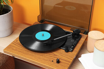 Stylish turntable with vinyl record on table indoors