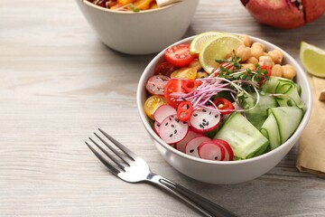 Bowl with many different vegetables on white wooden table. Vegan diet
