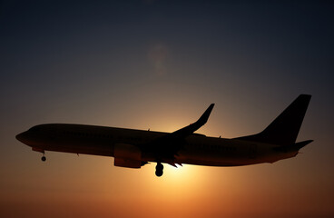 Fototapeta na wymiar Plane in sky against sun. Flight during sunset