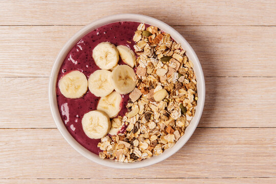 Acai bowl with muesli and sliced bananas 