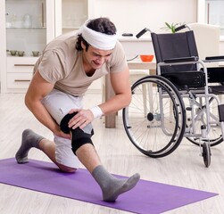 Obraz premium Injured young man doing exercises at home