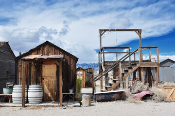 Gold Point in Nevada, USA. A ghost town with many abandoned houses, cars and no people. Background for horror movies. Famous spot in United States. Cloudy, blue sky.