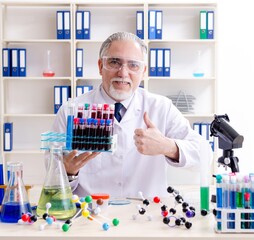 Fototapeta premium Old male chemist working in the lab