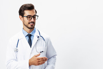 Male smile doctor in a white coat and eyeglasses and a stethoscope looks at the camera on a white isolated background, copy space, space for text, health