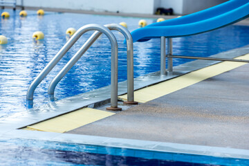 Ladder stainless handrails for descent into swimming pool. Swimming pool with handrail . Ladder of...