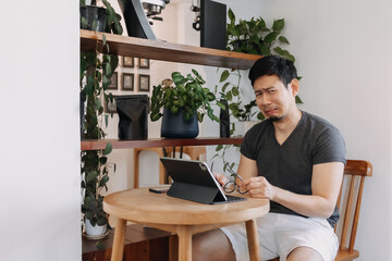 Funny face of sad freelance asian man working in the cafe.