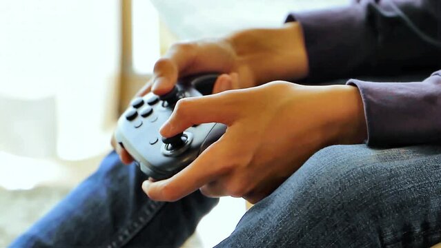 ゲームのコントローラーを操作する少年の手元