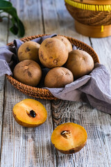 sawo or sapodilla fruit in basket on the wooden table
