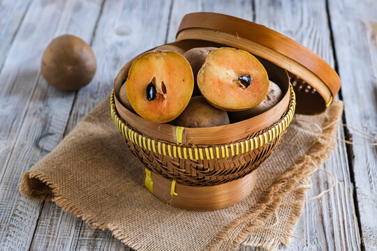 sawo or sapodilla fruit in basket on the wooden table
