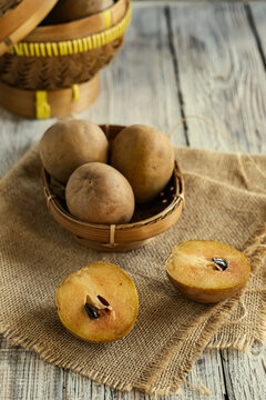 sawo or sapodilla fruit in basket on the wooden table
