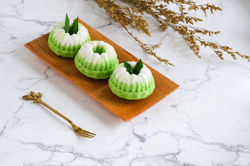 putu ayu is a green steamed cake with her signature floral print. the taste is soft and sweet and...