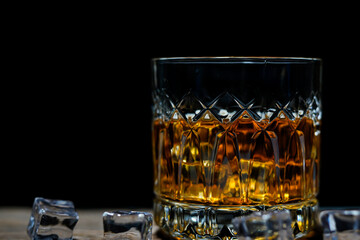 Pouring alcohol into glass, black background