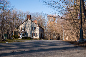 Old house with a chimney with shuttered windows in the park in the early spring. Spring season....