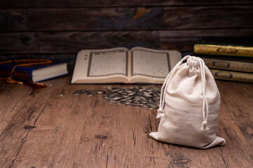 Hands holding a money bag for zakat, Islamic zakat concept. Muslims help the poor and needy. Conceptual shoot for property, income, and fitrah zakat.