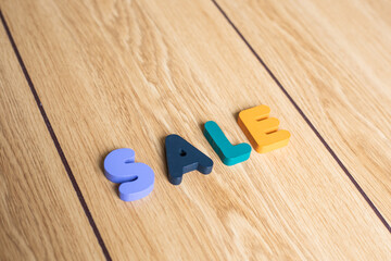 Closeup shot of colorful letter SALE lying on wooden background. Business idea. 