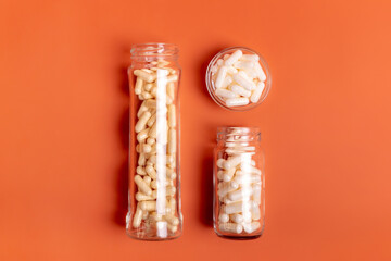 Food and dietary supplements, vitamin capsules in small glass bottles and in plate from above on...