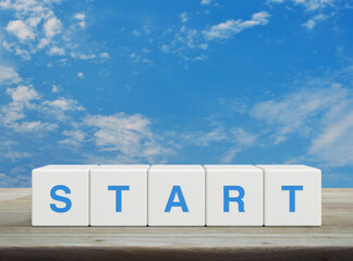 Start letter on white block cubes on wooden table over blue sky with white clouds, Business start up concept