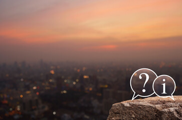 Question mark and information chat icon on rock mountain over blur of cityscape on warm light sundown, Technology customer service and support online concept