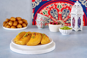 Arabian pancake Qatayef with cheese and walnuts. Traditional sweets with ramadan decor .