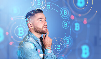 Pensive man and glowing hologram hud with bitcoins, cryptocurren