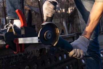 Cut aluminum profiles. A master at work gloves saws off the aluminum profile with an angle grinder. - obrazy, fototapety, plakaty