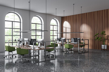 Stylish coworking interior with pc computer and arched panoramic window